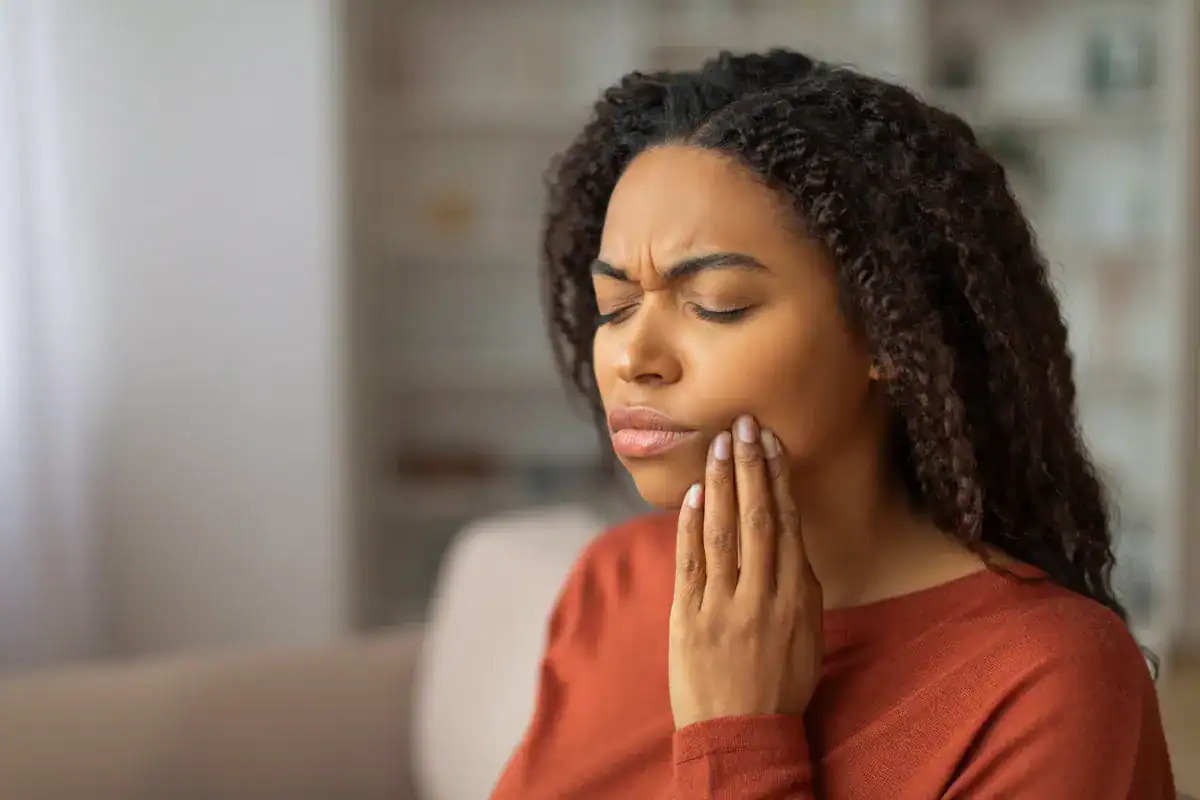 Severe toothache causing woman to hold jaw, dental pain, dental emergency, Rincon Dental.